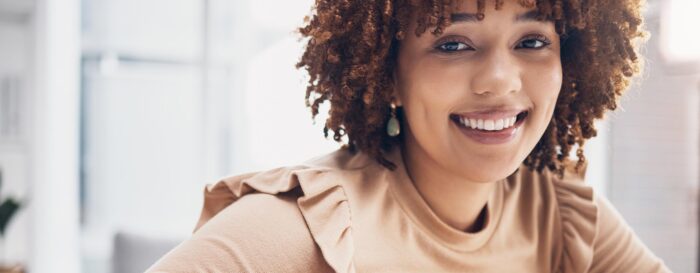 woman with curly hair smiling at the camera