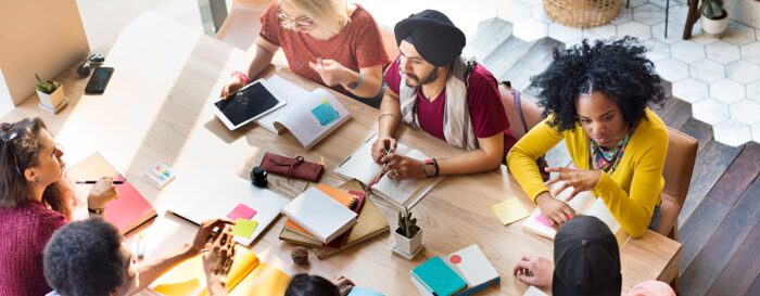 team of diverse workers at a table discussing business plans